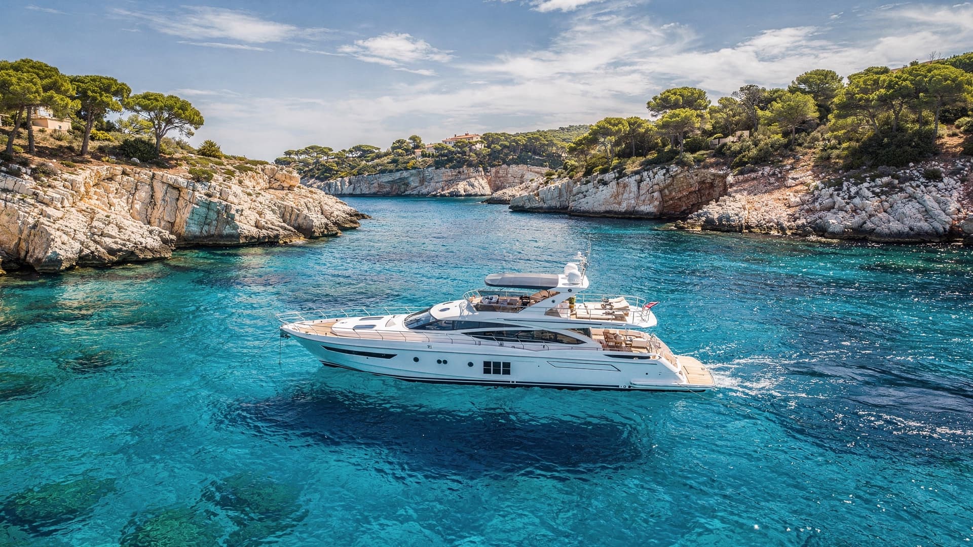 Vue aérienne d’un yacht moderne ancré dans une crique turquoise de la Riviera